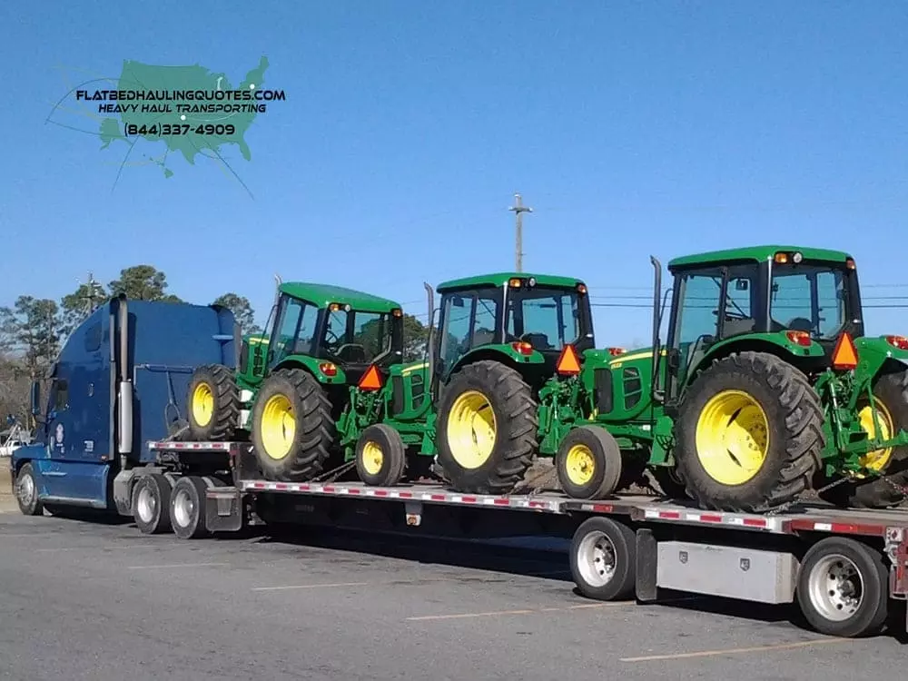 moving heavy haul tractors on flatbed truck trailor Shipping Oversized Towers | Heavy Haul Transportation Services